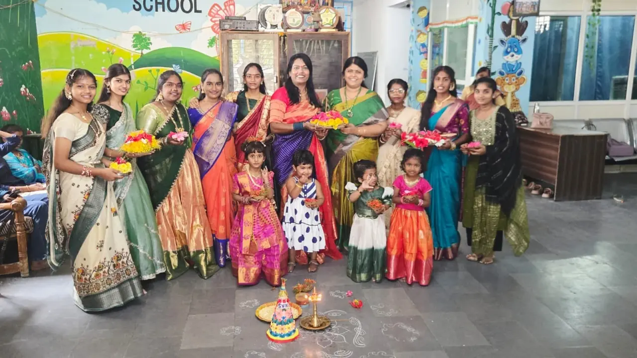 Teachers and children celebrating Bathukamma with flower stacks