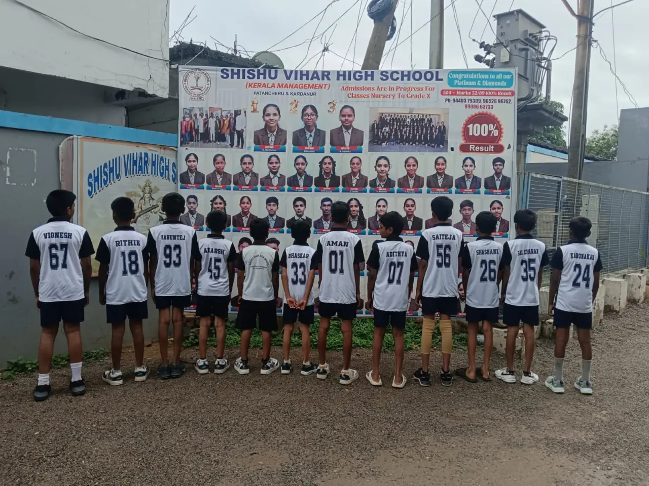 Students in sports jerseys looking up at the school's wall of SSC toppers